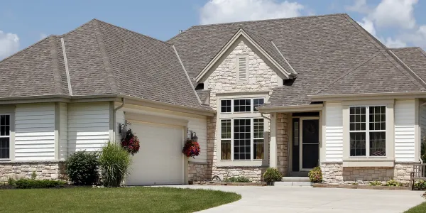 exterior of nice home with white siding and stone walls